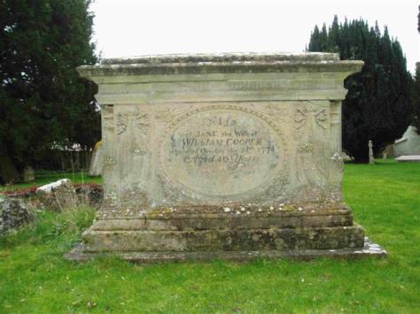 Stone monument with engraved inscriptions set in a grassy area surrounded by trees, showcasing historical significance and craftsmanship.